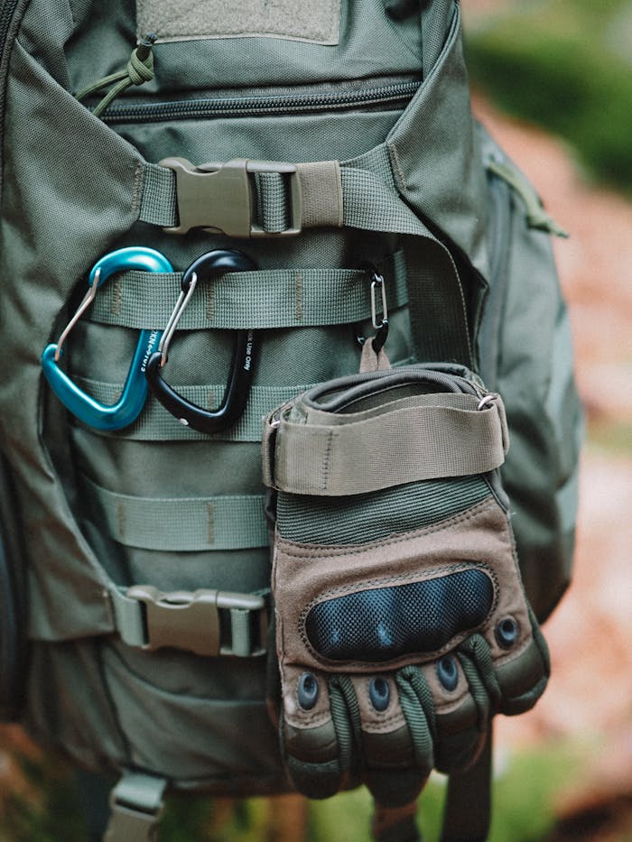 Close-up of Climbing Carabiners and a Glove Attached to a Backpack